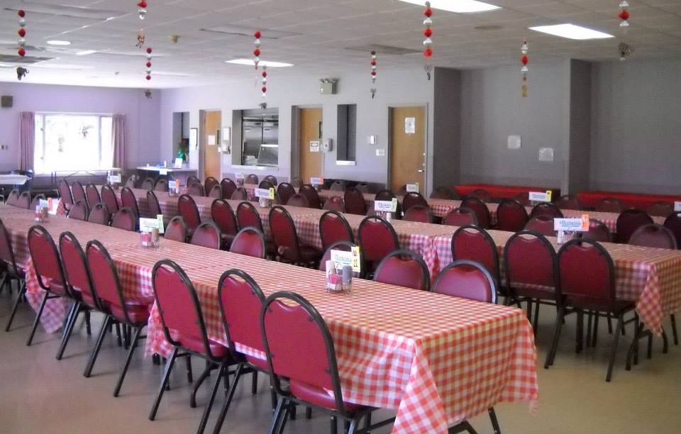 Ben Wilson Senior Activity Center Event Venue with rectangle tables and red and white checkered table cloths on top.